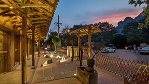 Un edificio de madera con galería techada y escalones de piedra.
