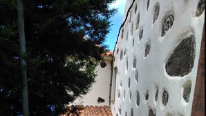 Unes escales estretes que condueixen a un edifici amb teulada de rajola i una porta de fusta.