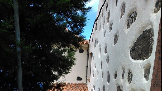 A narrow stairway leading to a building with a tiled roof and a wooden door. - Quiet apartment with sea views (Agulo)