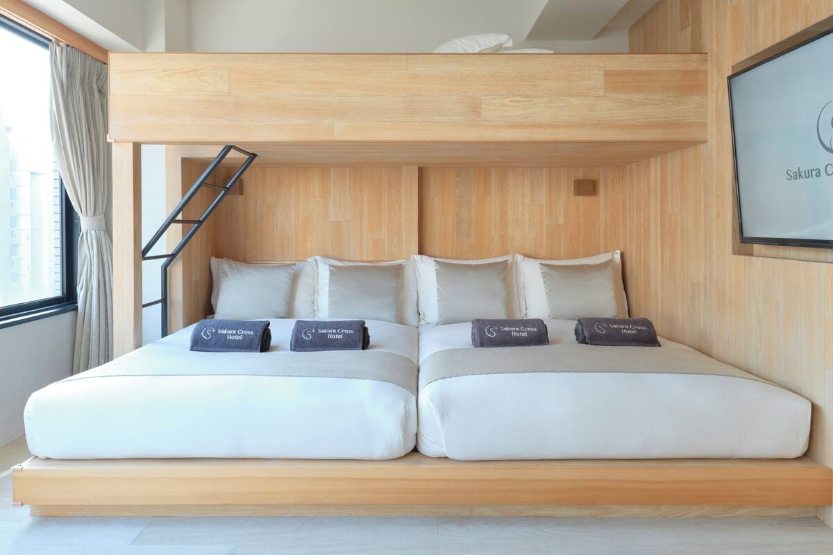 Una habitación de hotel moderna con una litera, una escalera y un cuadro en la pared.