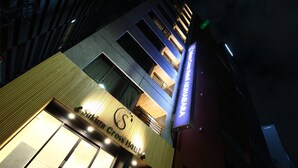 Entrada de un hotel con un cartel que dice 'The Cross Hotel' y un logotipo con la letra 'S'.