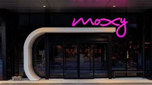 A modern building entrance with a curved facade and a neon sign that reads "mozy". - Moxy Atlanta Midtown (Atlanta)