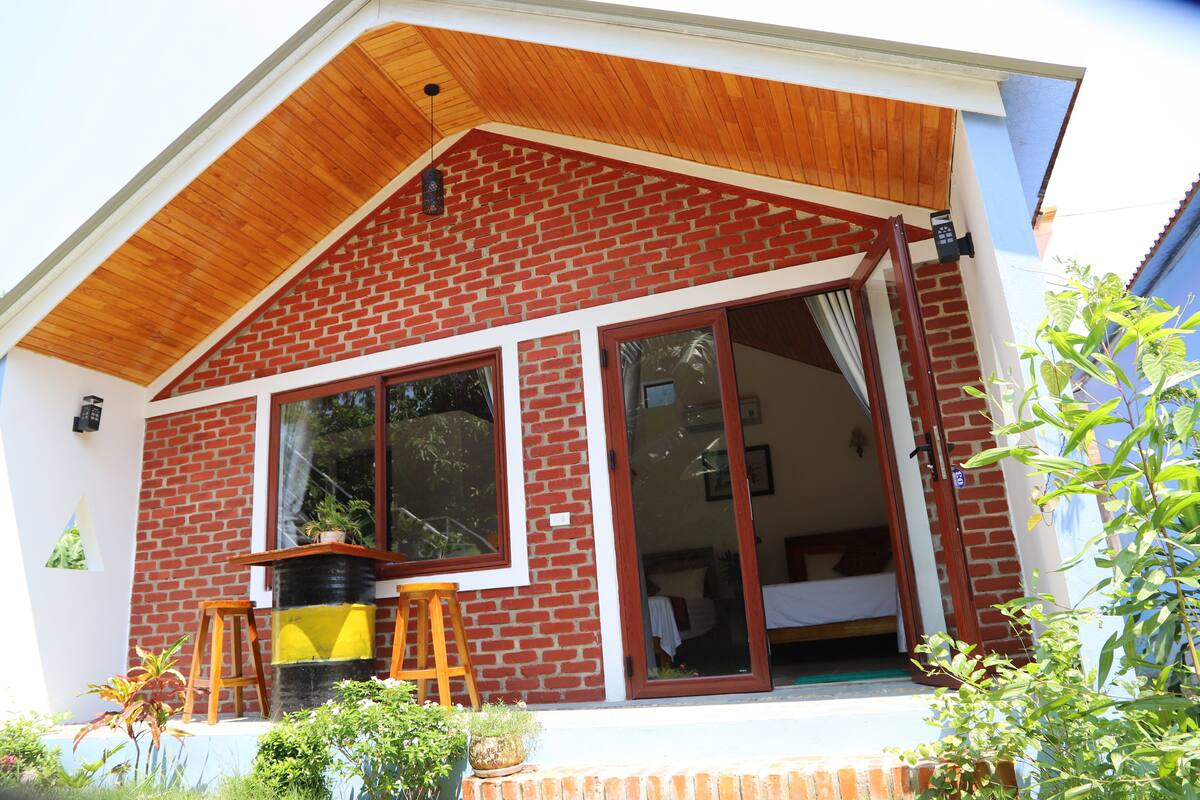 Una casa moderna con fachada de ladrillo, grandes puertas correderas de vidrio y un porche de madera.