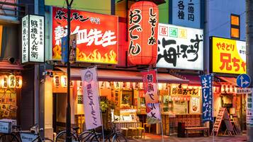 A street with various signs and storefronts, including a restaurant with a red lantern and a sign with flames.