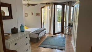 Een slaapkamer met een bed, een kaptafel en uitzicht op buiten.