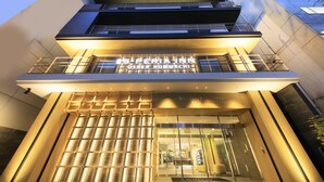 A modern building with a prominent entrance and illuminated signage.