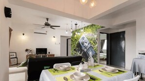 A dining area with a table set for two, a ceiling fan, and a wall-mounted air conditioner. - Desa Kiara Cozy Condo by SYNC (Kuala Lumpur)