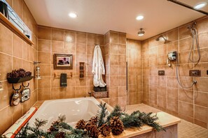 A bathroom with a bathtub, shower, and tiled walls.