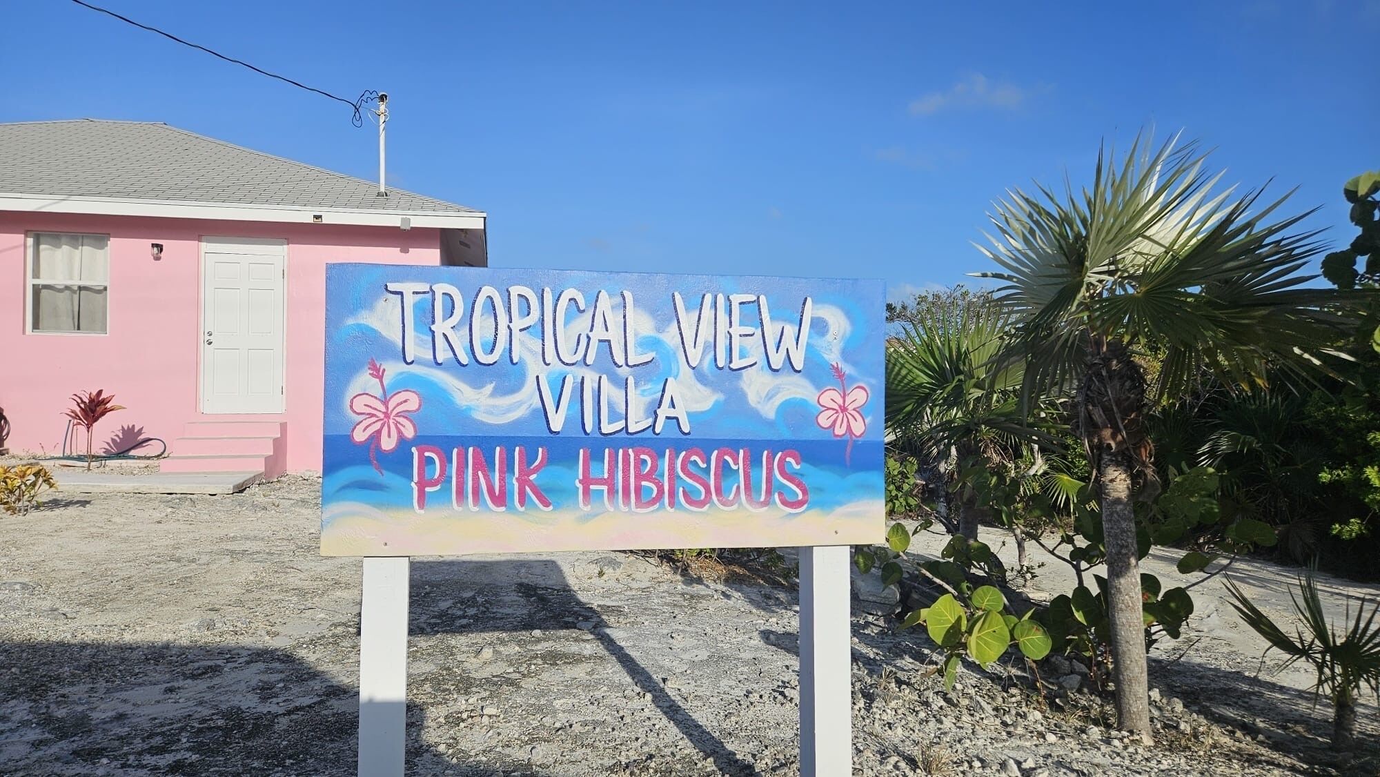 En skylt för villan Tropical View, med ett rosa hibiskusmotiv.