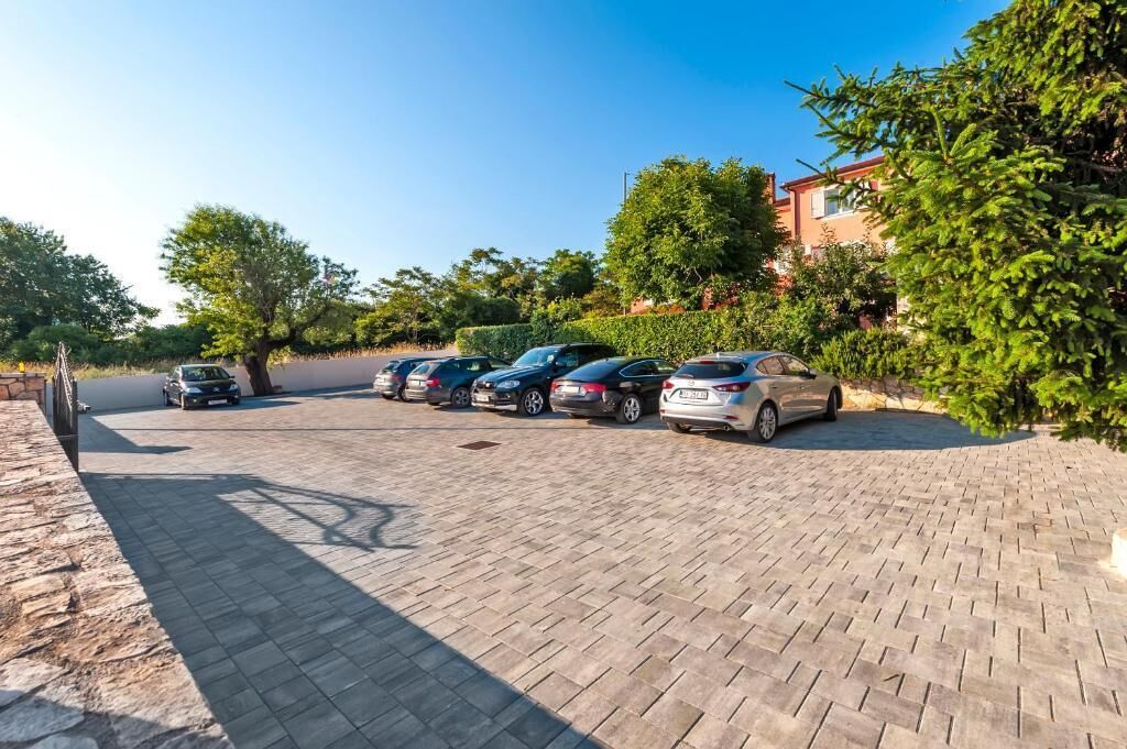 A paved parking area with several cars parked.