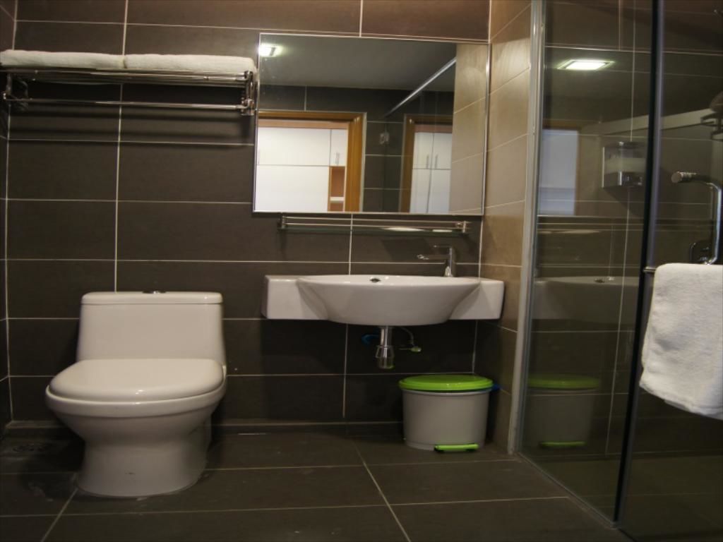 A bathroom with a toilet, sink, and shower.
