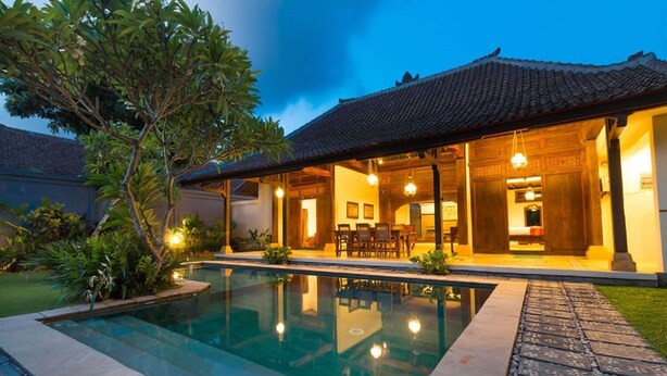 A modern house with a swimming pool, a dining area, and a well-maintained garden. - Bali Royal Heritage Villas (Keroboken Kelod)