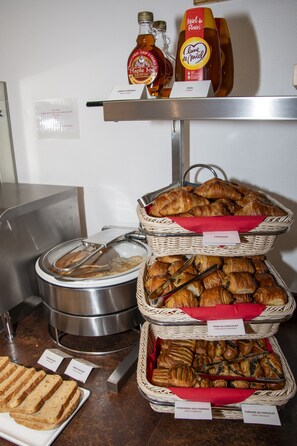 A buffet with various food items including bread, pastries, and condiments. - K Hotel (Strasbourg)