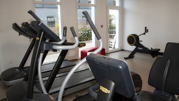 A gym with treadmills, stationary bikes, and exercise equipment.
