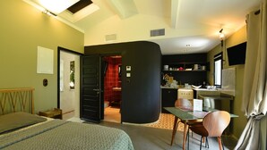 A hotel room with a bed, a desk, and a kitchenette. - Appart'sHotel Fior Di Ribba (Sartene)