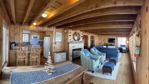 A wooden cabin interior with a kitchen, dining area, and living room. - Oceanfront, Private Beach Access, Newly Updated, Perfect for Family Gatherings! (Lincoln City)