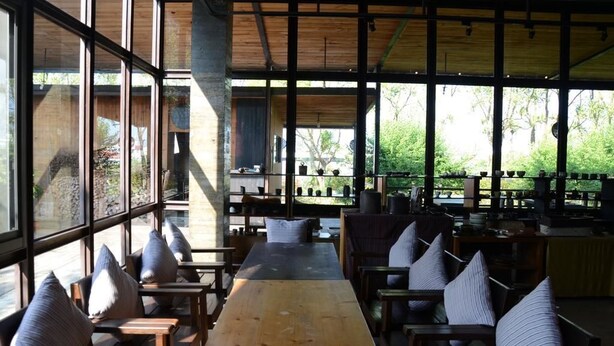 A spacious indoor area with large windows, wooden tables, and chairs arranged for dining or socializing. - SHYE Lithuania Homestay (Taichung)