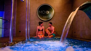 Un área de spa con un cartel que dice "MOON spa" y dos personas sentadas en un jacuzzi.