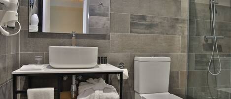 A modern bathroom with a sink, mirror, and toilet.