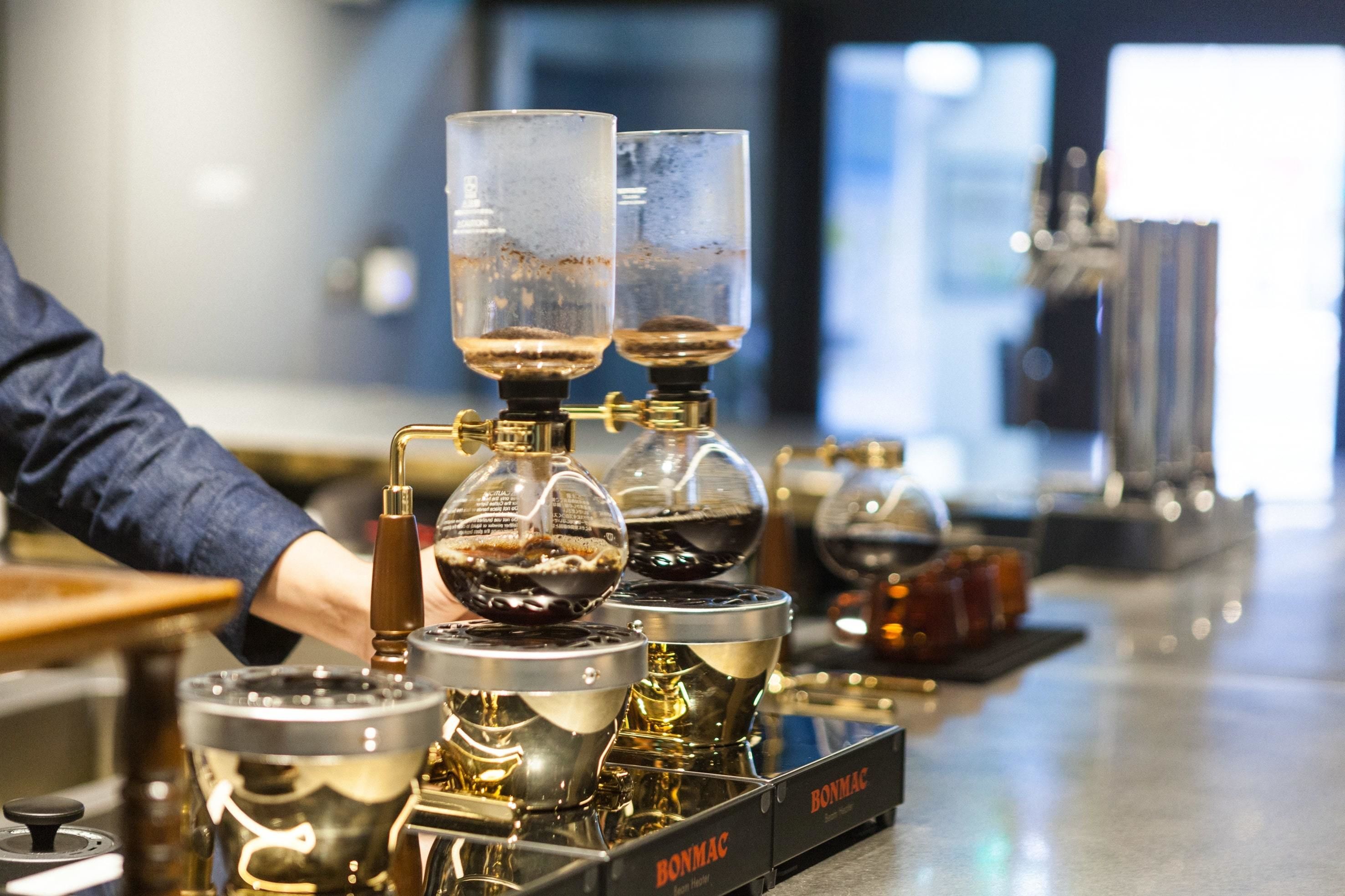 A coffee machine with multiple brewing stations, each with a glass container and a spout.