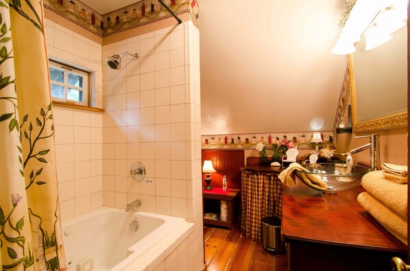 Un baño con bañera, ducha, tocador con espejo y lavamanos.