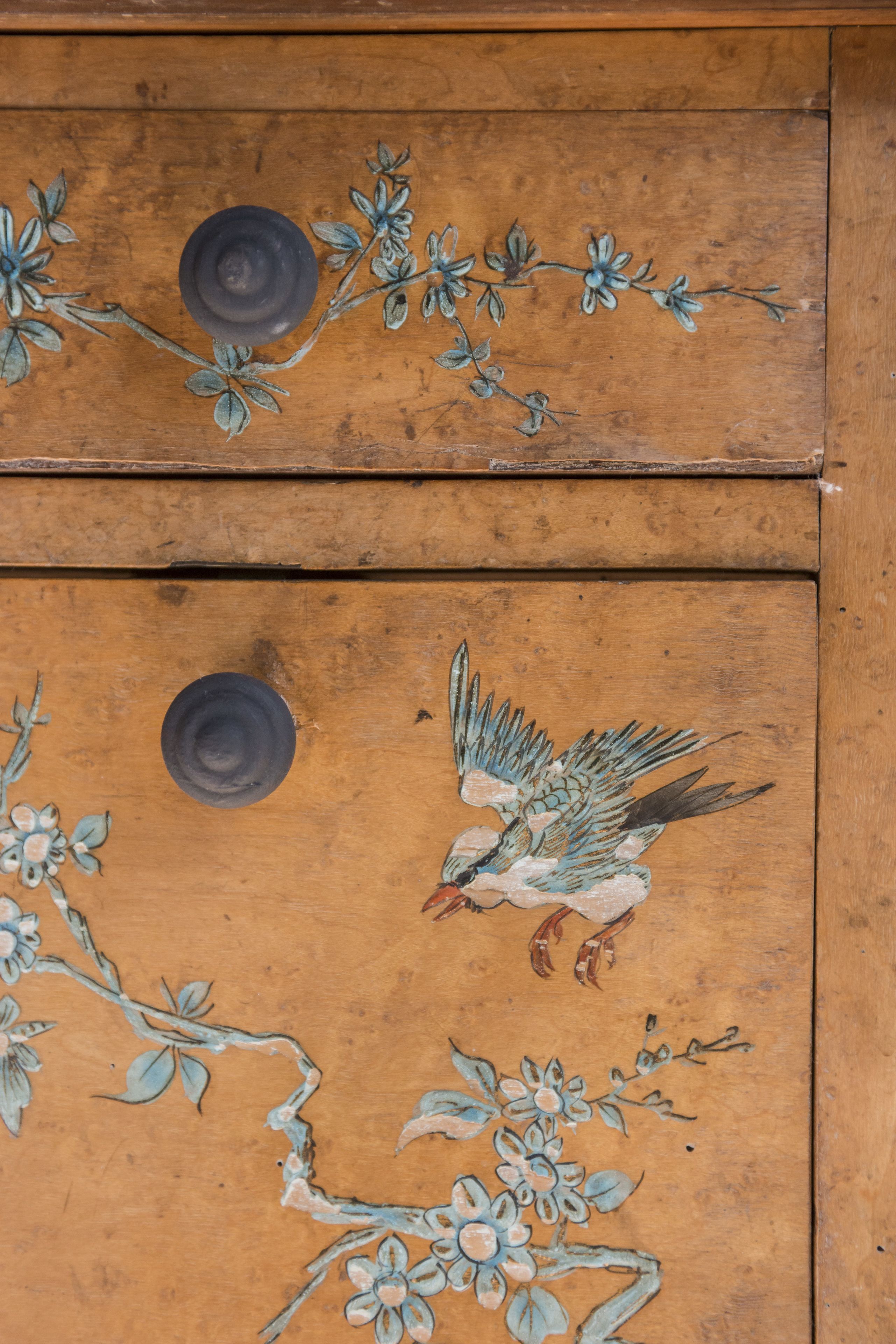 Un meuble en bois orné de motifs floraux et d’oiseaux.