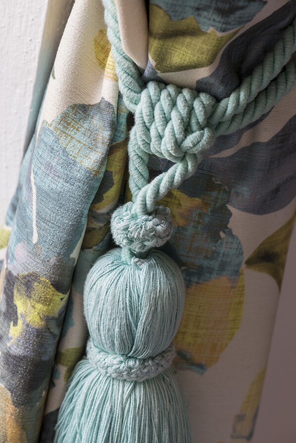 A close-up of a fabric with a floral pattern and a rope tied in a knot. - Maison le Village (Montagny-les-Beaune)