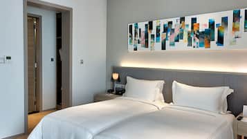 Et moderne hotelværelse med en stor seng, et natbord og et kunstværk på væggen.