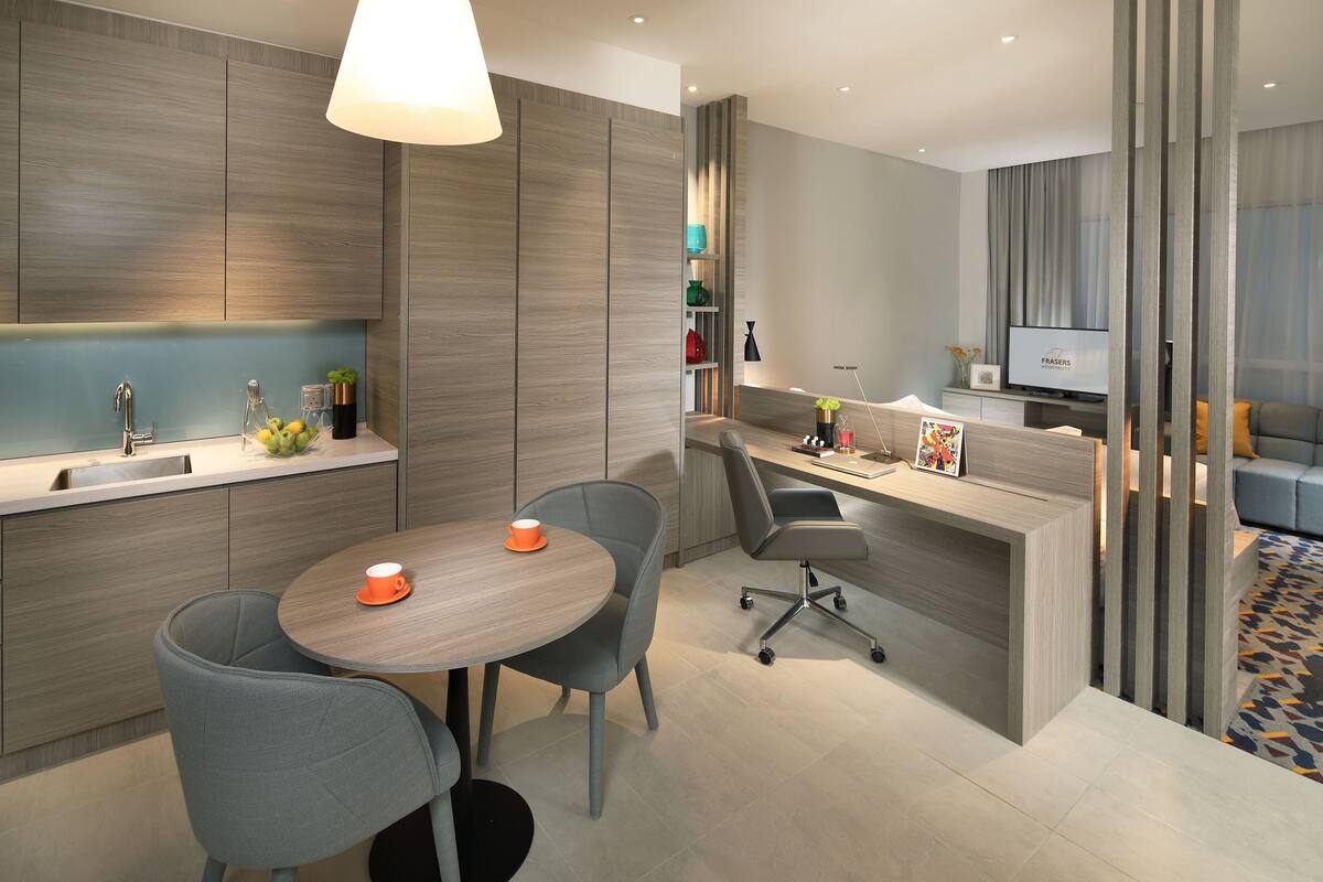 Une cuisine moderne avec un coin repas, un téléviseur intégré et un espace détente comprenant un canapé et une table basse.