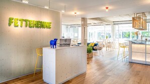 A reception desk with a wooden backdrop and a sign reading "FETTEHENNE". - Fettehenne Gästehaus (Erkrath)