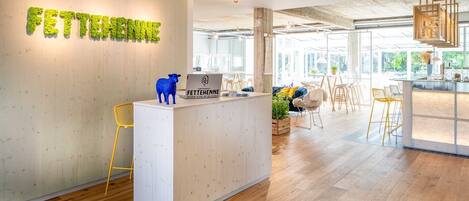 A reception desk with a wooden backdrop and a sign reading "FETTEHENNE".