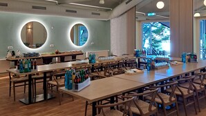 A spacious restaurant with round tables, wooden chairs, and hanging pendant lights. - Fettehenne Gästehaus (Erkrath)