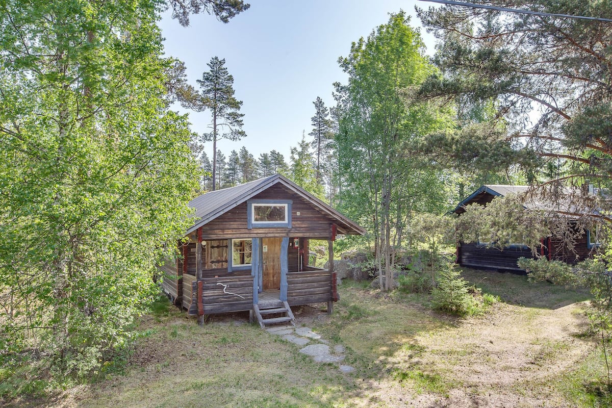 A rustic cabin surrounded by dense forest.