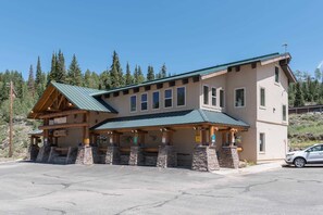 A lodge with a green roof, stone pillars, and a sign indicating a restaurant.