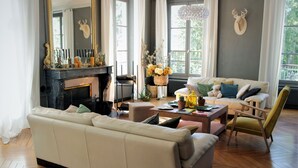 A spacious living room with a fireplace, a sofa, a coffee table, and a chair. - Les Rives de la Tronne (Mer)