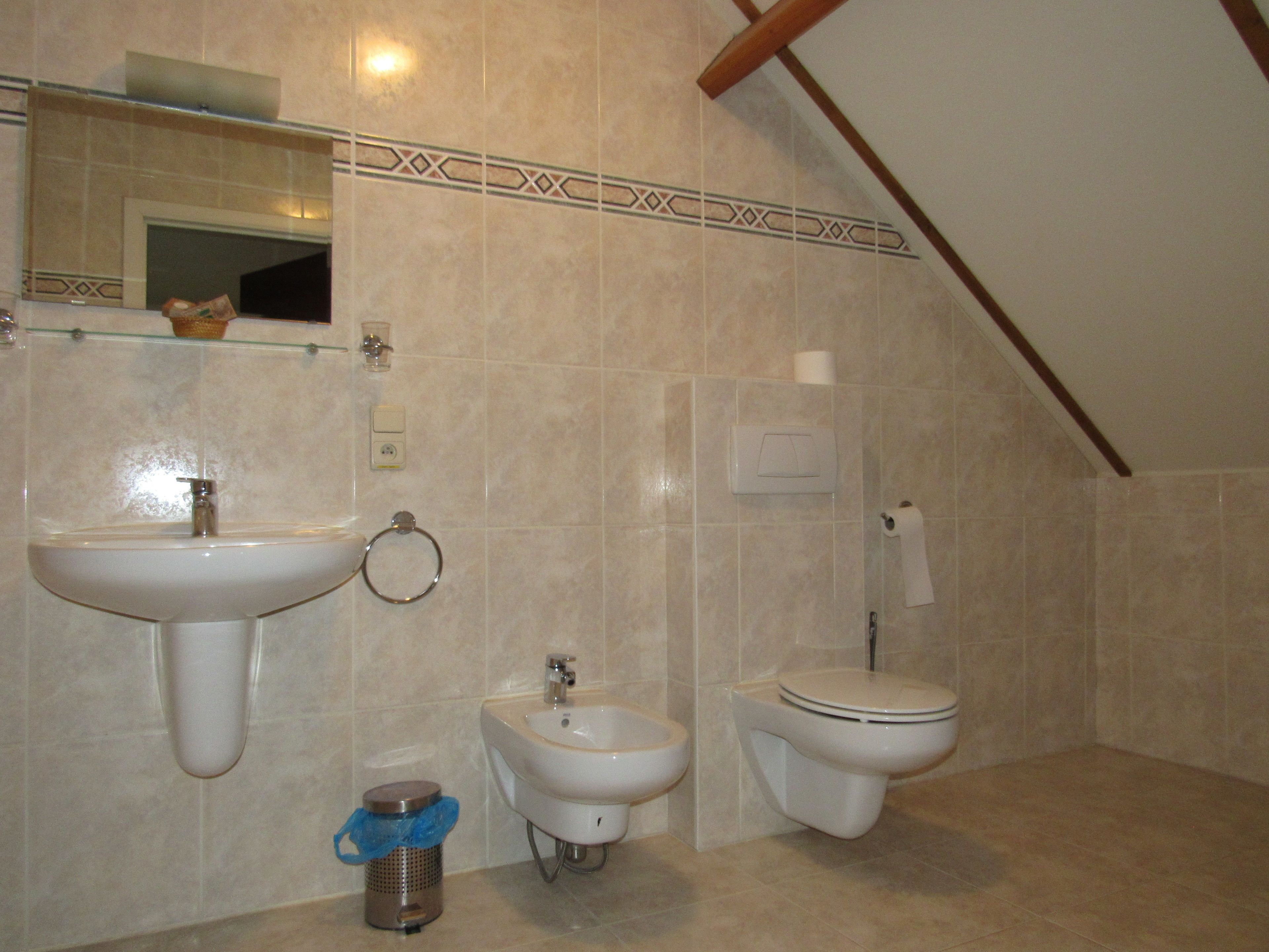 Un baño con lavabo, bidé, inodoro y espejo.