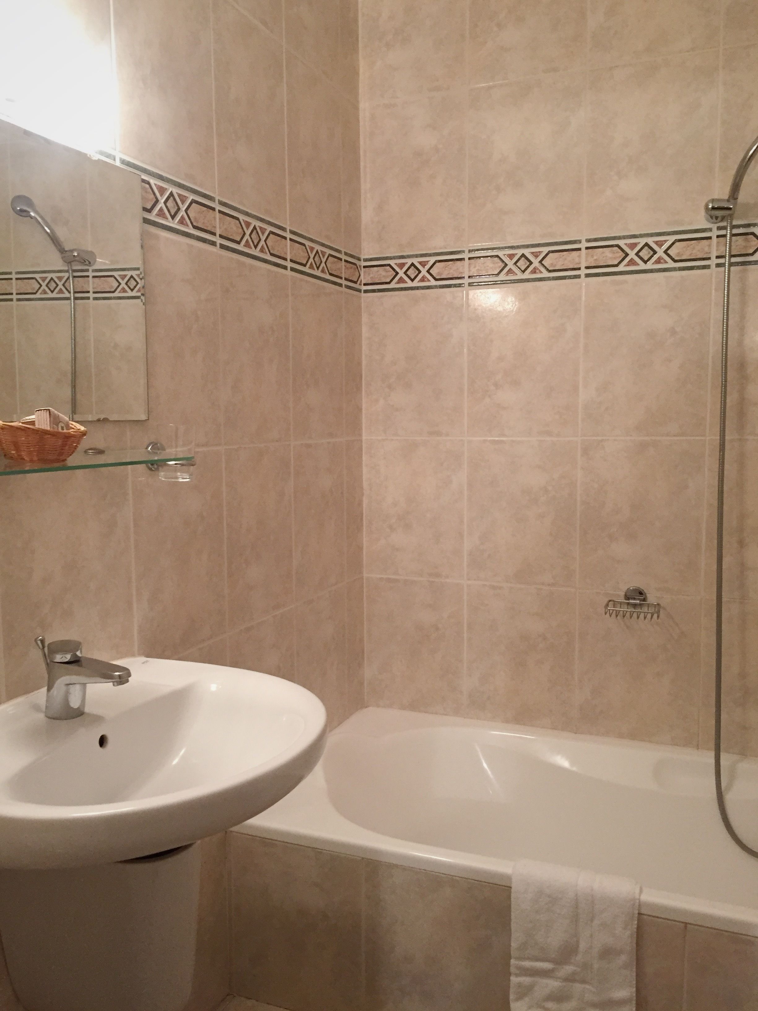 Un baño con lavabo, espejo y bañera.