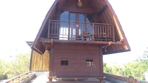 A wooden cabin with a balcony and large windows. - Jepun Sari Uluwatu (Pecatu)