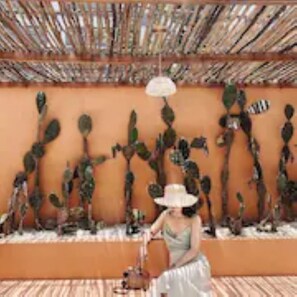 A room with a cactus wall art, a hanging light fixture, and a patterned floor. - The Mansion Hoi An by Minova (Da Nang)