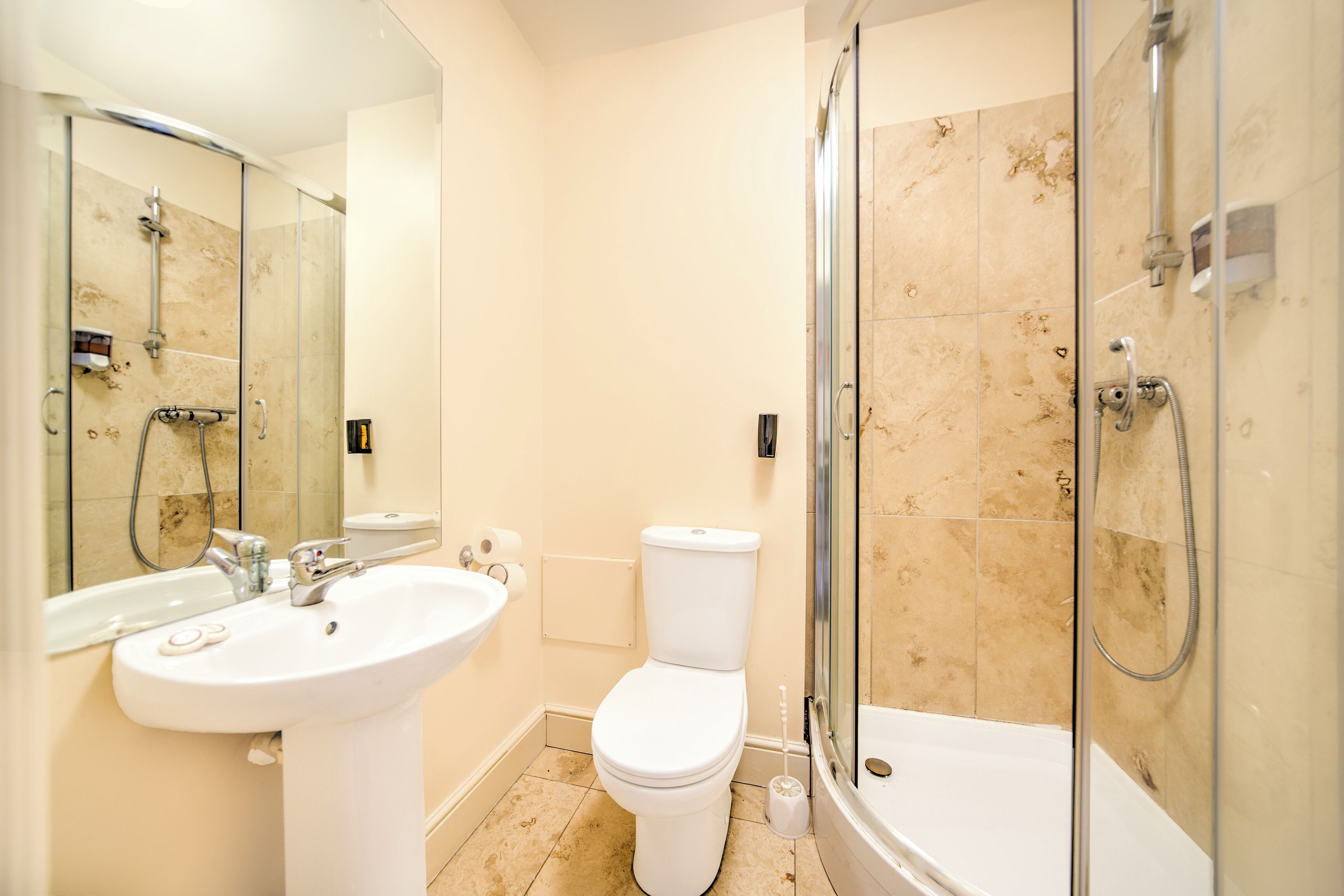 A modern bathroom with a sink, toilet, and glass-enclosed shower.