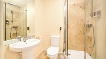 A modern bathroom with a sink, toilet, and glass-enclosed shower.