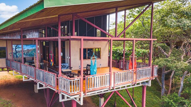 Ein zweistöckiges Gebäude mit Balkon und überdachter Veranda.