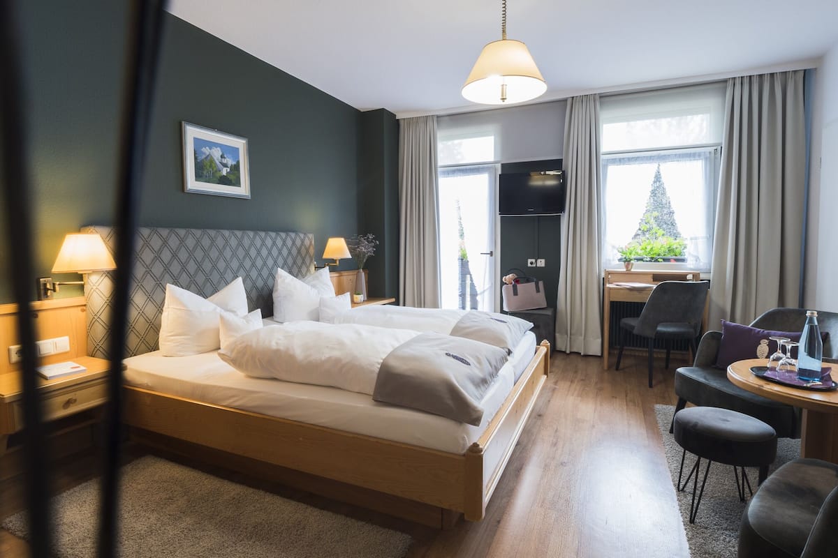 Een hotelkamer met een groot bed, een bureau en een stoel.