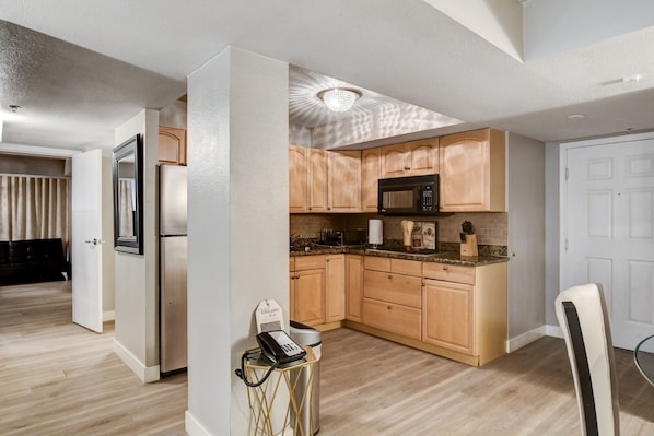 A modern kitchen with wooden cabinets, a microwave, and a stainless steel refrigerator. - Gorgeous, Luxurious Penthouse Next to Bellagio on the Strip! Call 702-987-6904. (Las Vegas)