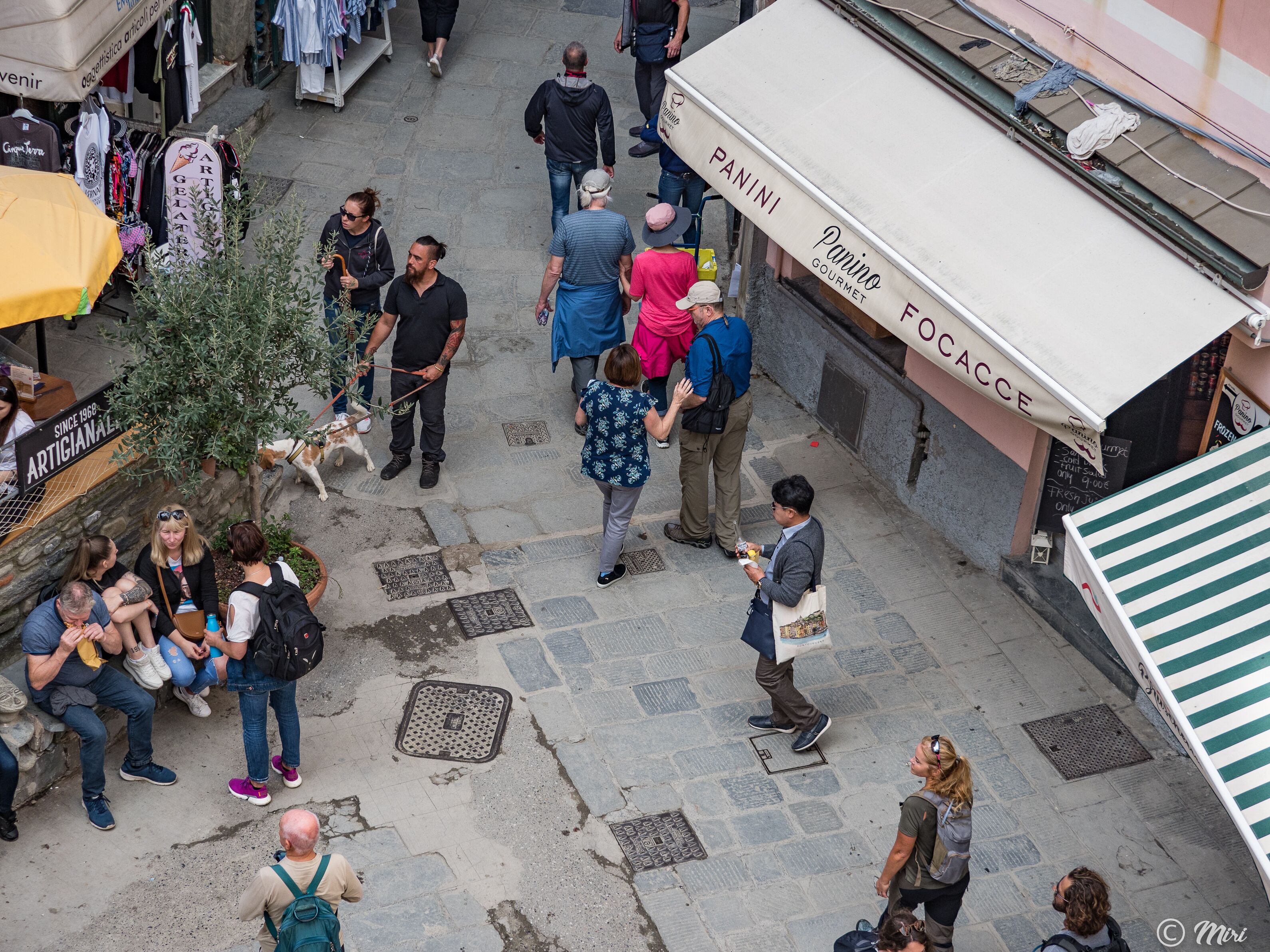 A busy outdoor market area with various stalls and people walking around.