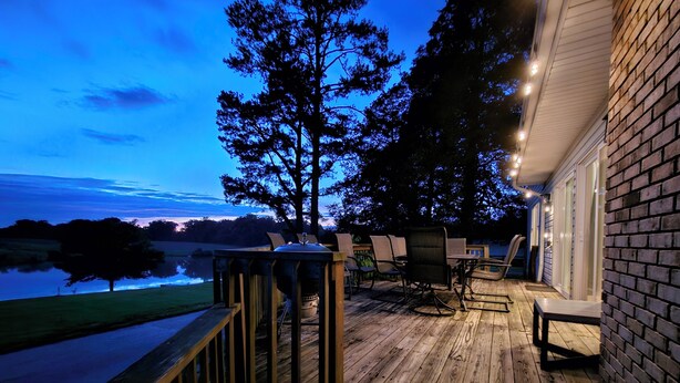 A wooden deck with outdoor furniture, overlooking a body of water and a tree. - Wine Country Farmhouse Private Lake! kayaks Fire Pit! On The Wine Trail! (Cobden)