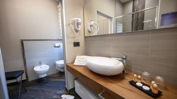 Ein modernes Badezimmer mit einem großen, weißen Waschbecken, einem Bidet und einer Holzeinrichtung.
