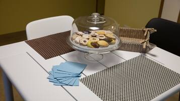 Un tavolo con una vetrina a cupola per dolci, un sottopiattino decorato e tovaglioli azzurri.