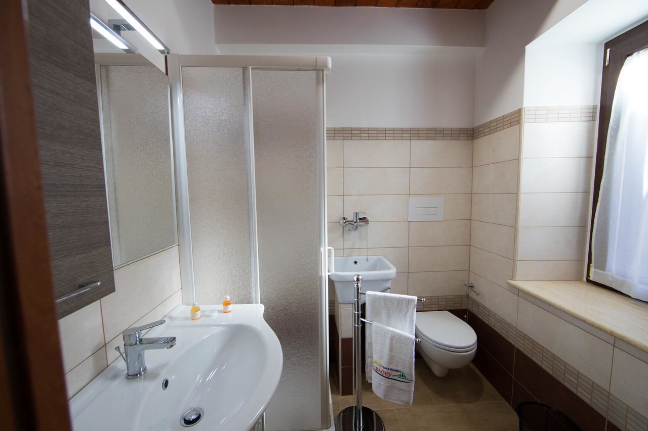 A bathroom with a sink, mirror, shower, and toilet.