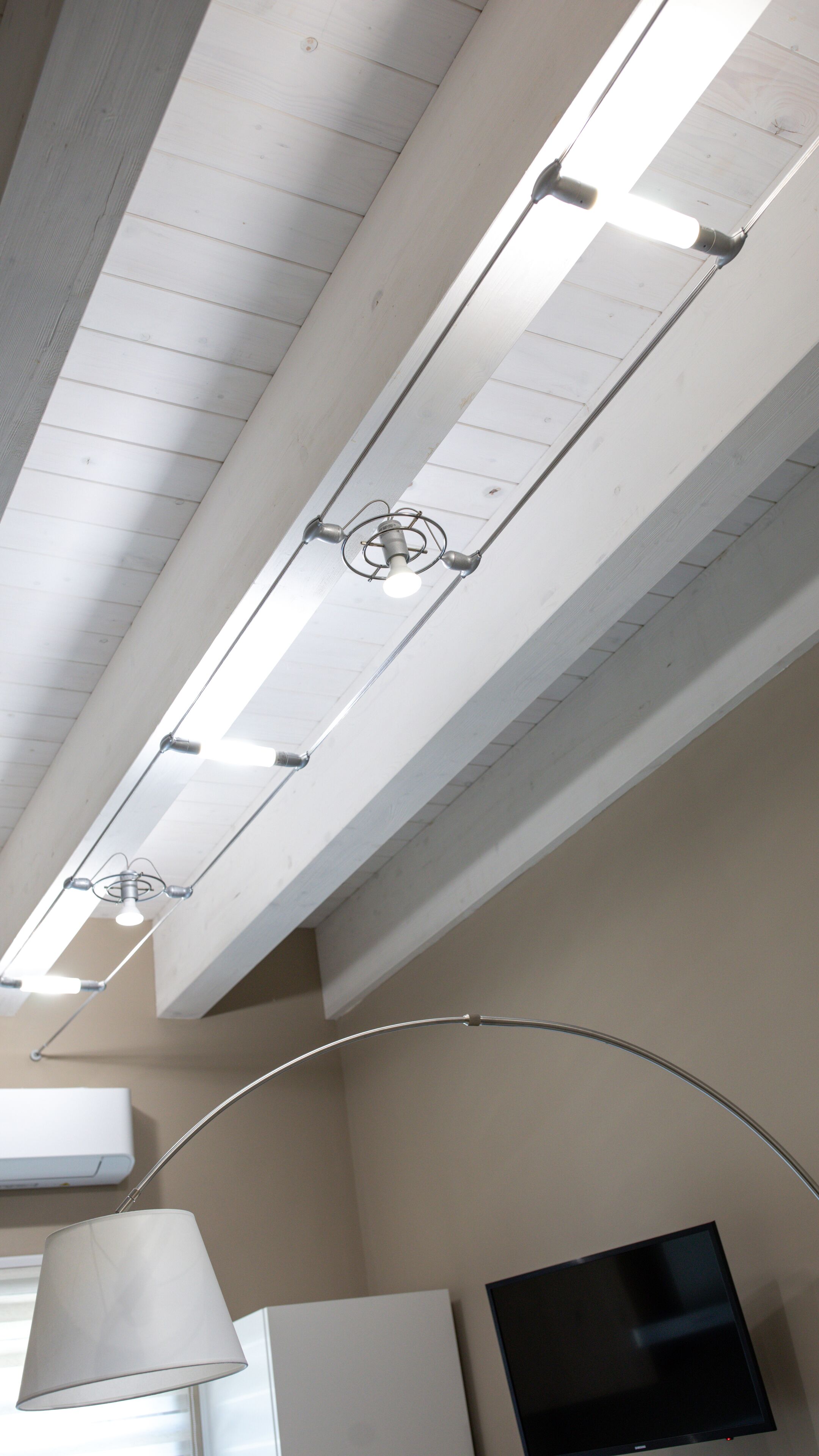 Un plafond doté de luminaires fluorescents et d’un lustre moderne suspendu.